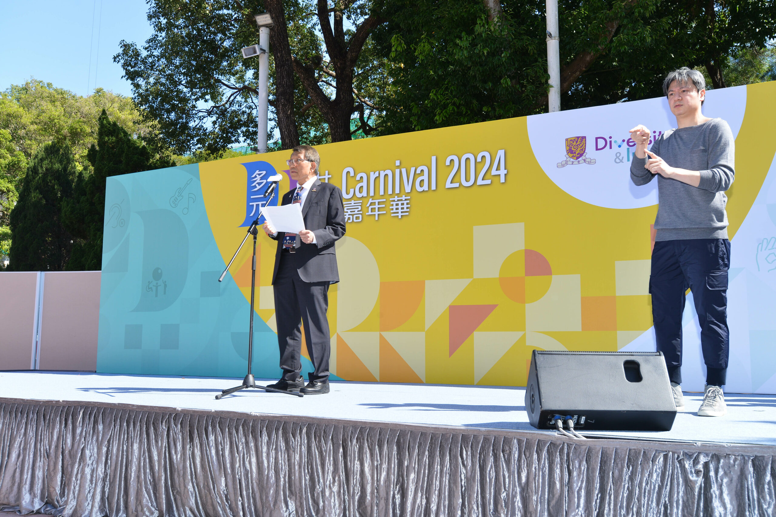 Rocky Tuan, Vice-Chancellor of the CUHK, delivers the opening speech on stage. A sign language interpreter is next to him.