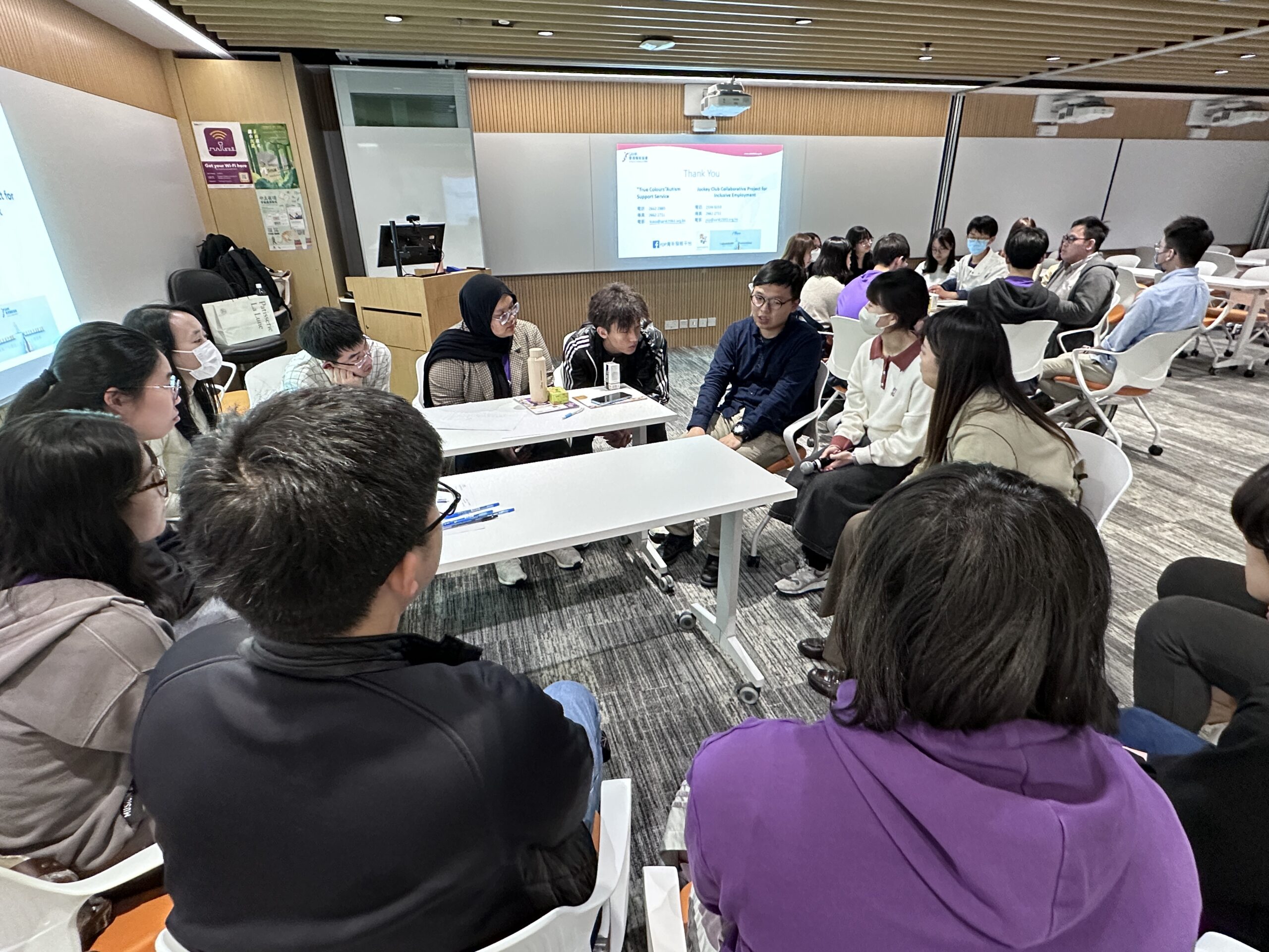 A group of people sits in a circular formation in a classroom or conference room. Individuals with special educational needs graciously shared their personal narratives as well as the challenges they faced in academic and daily life.