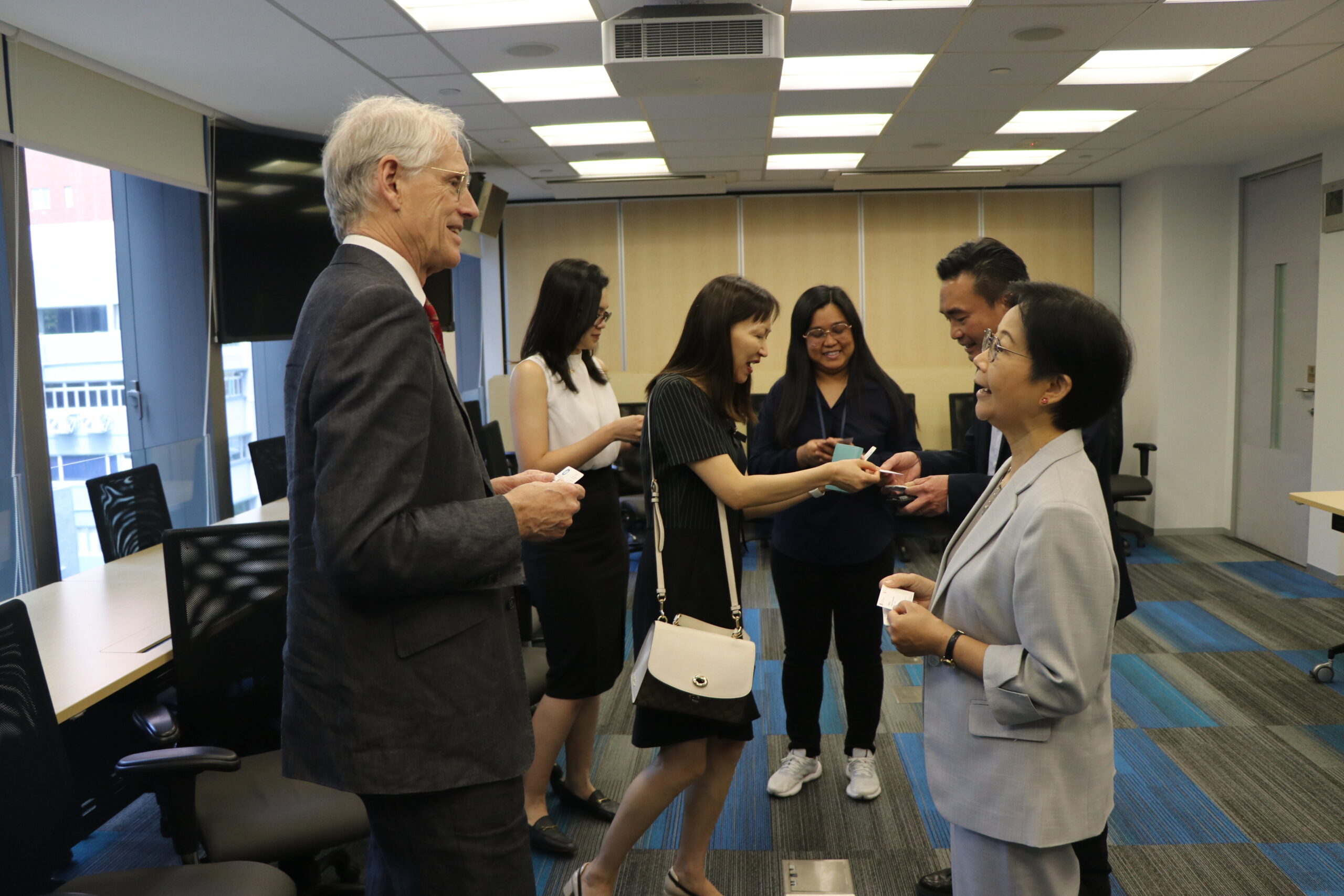 A professional setting with six individuals engaged in conversation or networking