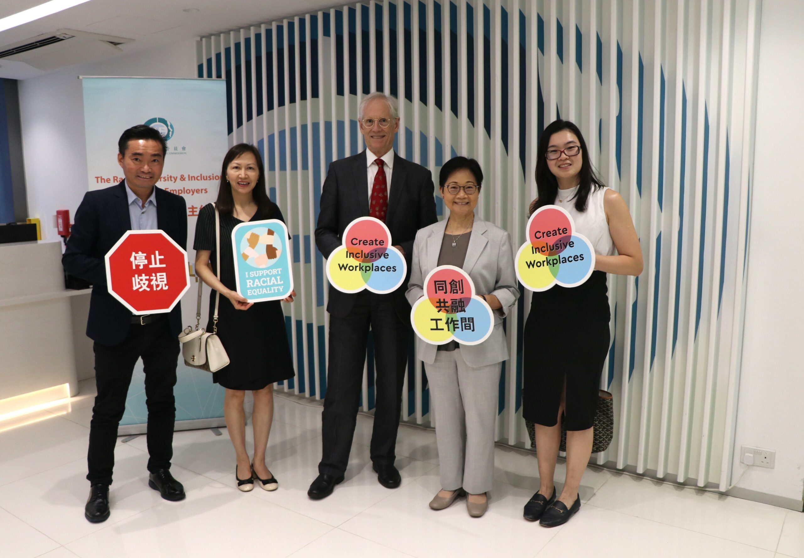 Prof. Nick Rawlins and oter representatives from CUHK and EOC holding signs that promote inclusivity and equality, including messages like "Stop Discrimination" and "I Support Racial Equality."